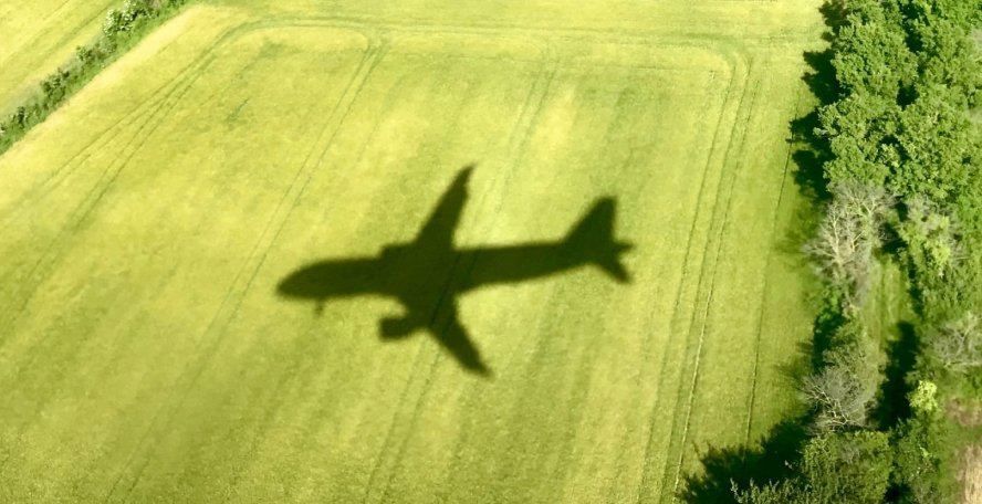 Vue de l'ombre d'un avion sur un champ